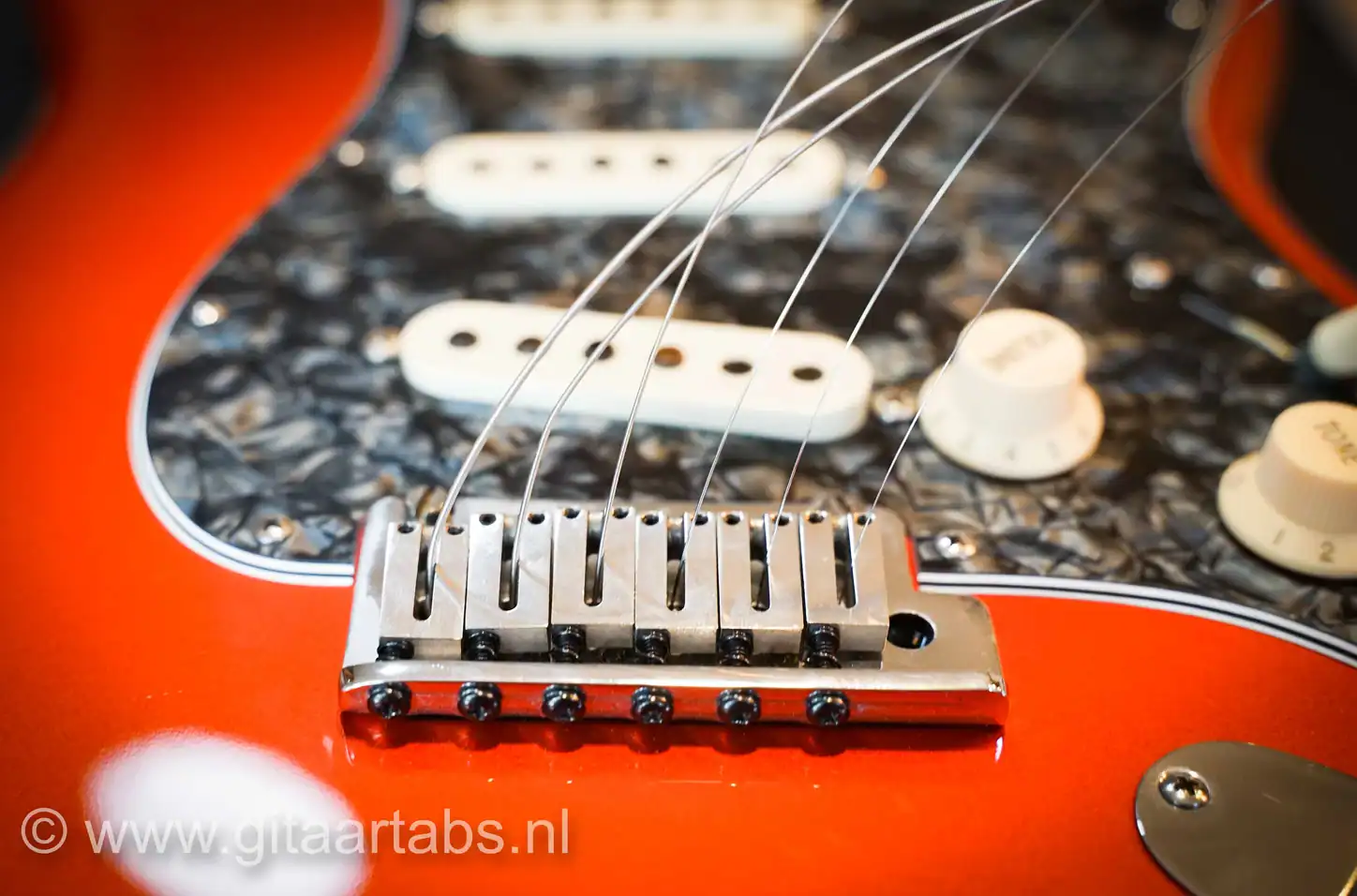 Gitaarsnaren door brug van elektrische gitaar