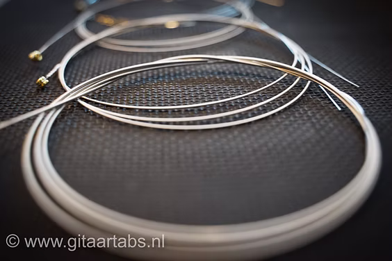 Elektrische gitaarsnaren op zwarte ondergrond